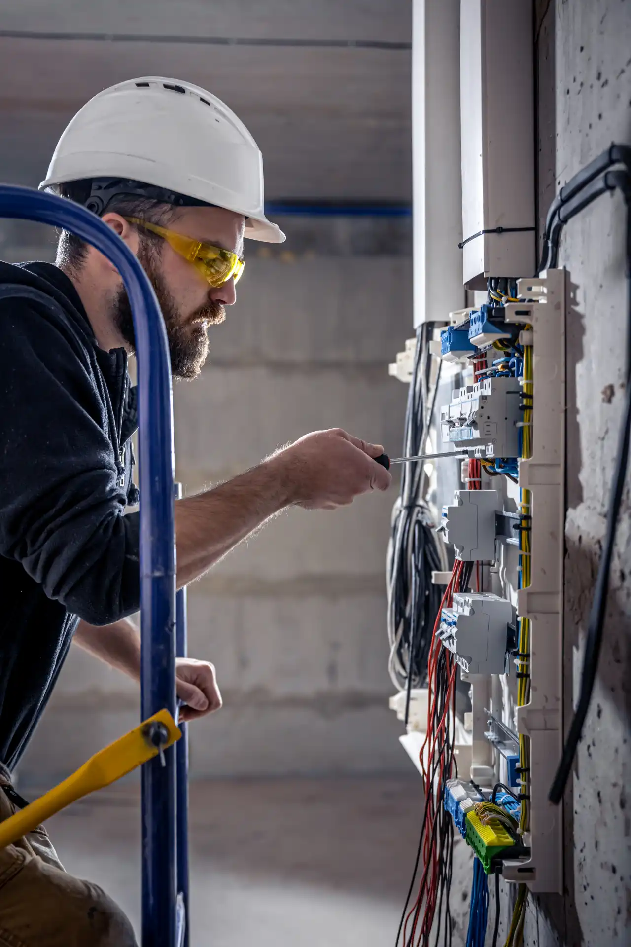 a-male-electrician-works-in-a-switchboard-with-an-2025-03-13-03-08-57-utc