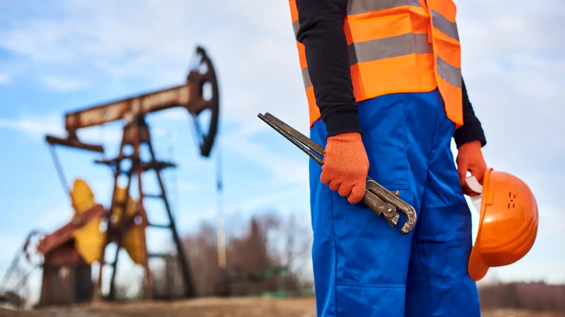 oil-worker-holding-protective-helmet-and-industria-2025-01-16-22-16-51-utc